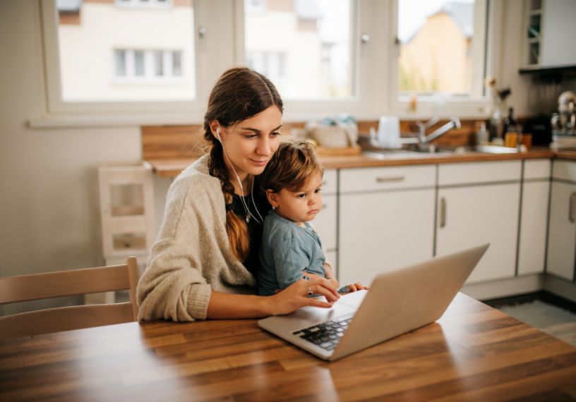 Woman looking at a computer with a child on her lap