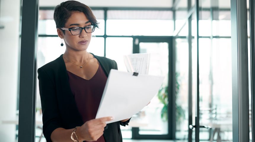 A woman looking at a stack of paper